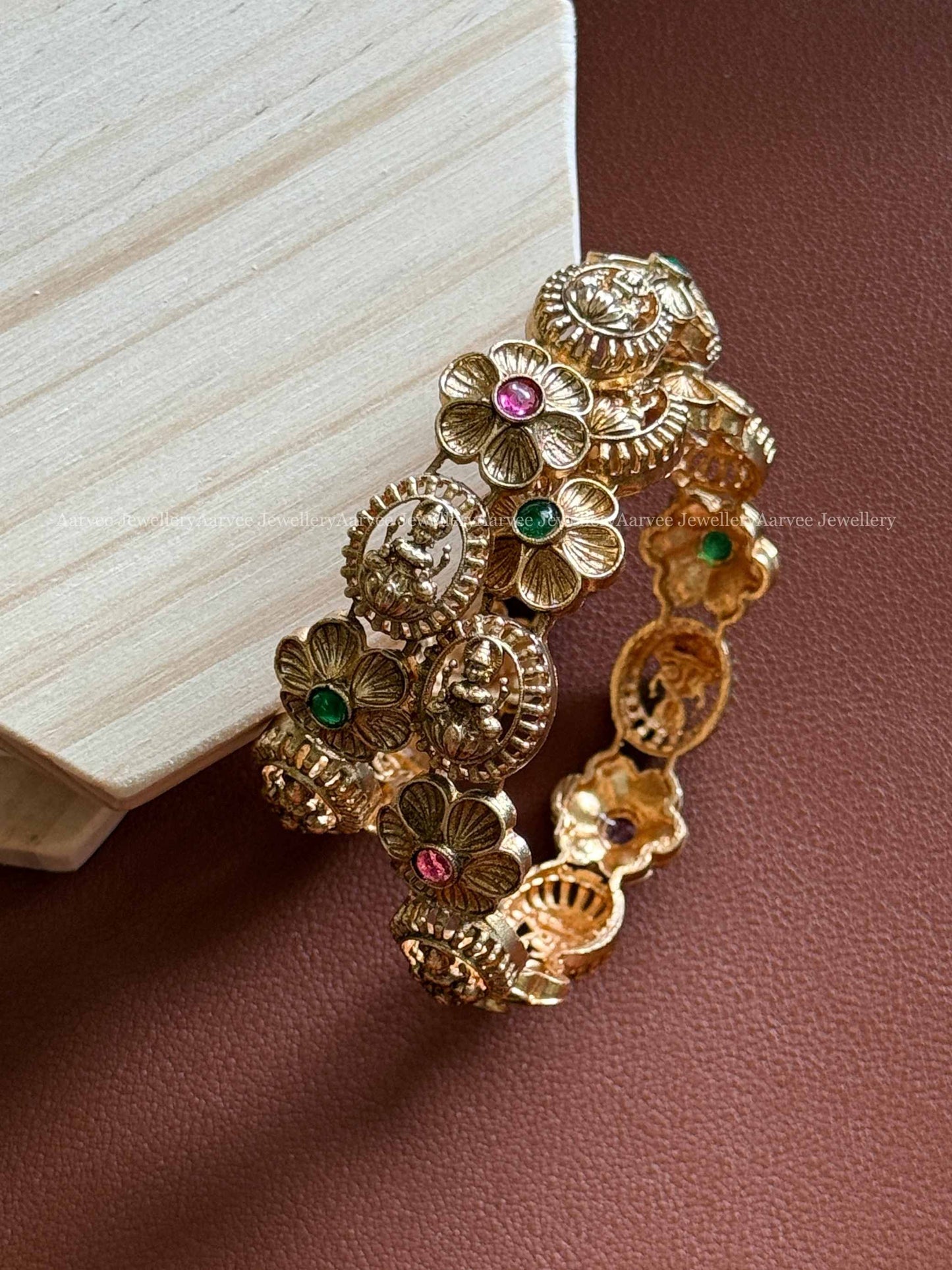 GOLD FINISH LAKSHMI AND FLORAL BANGELS IN RUBY / GREEN STONE