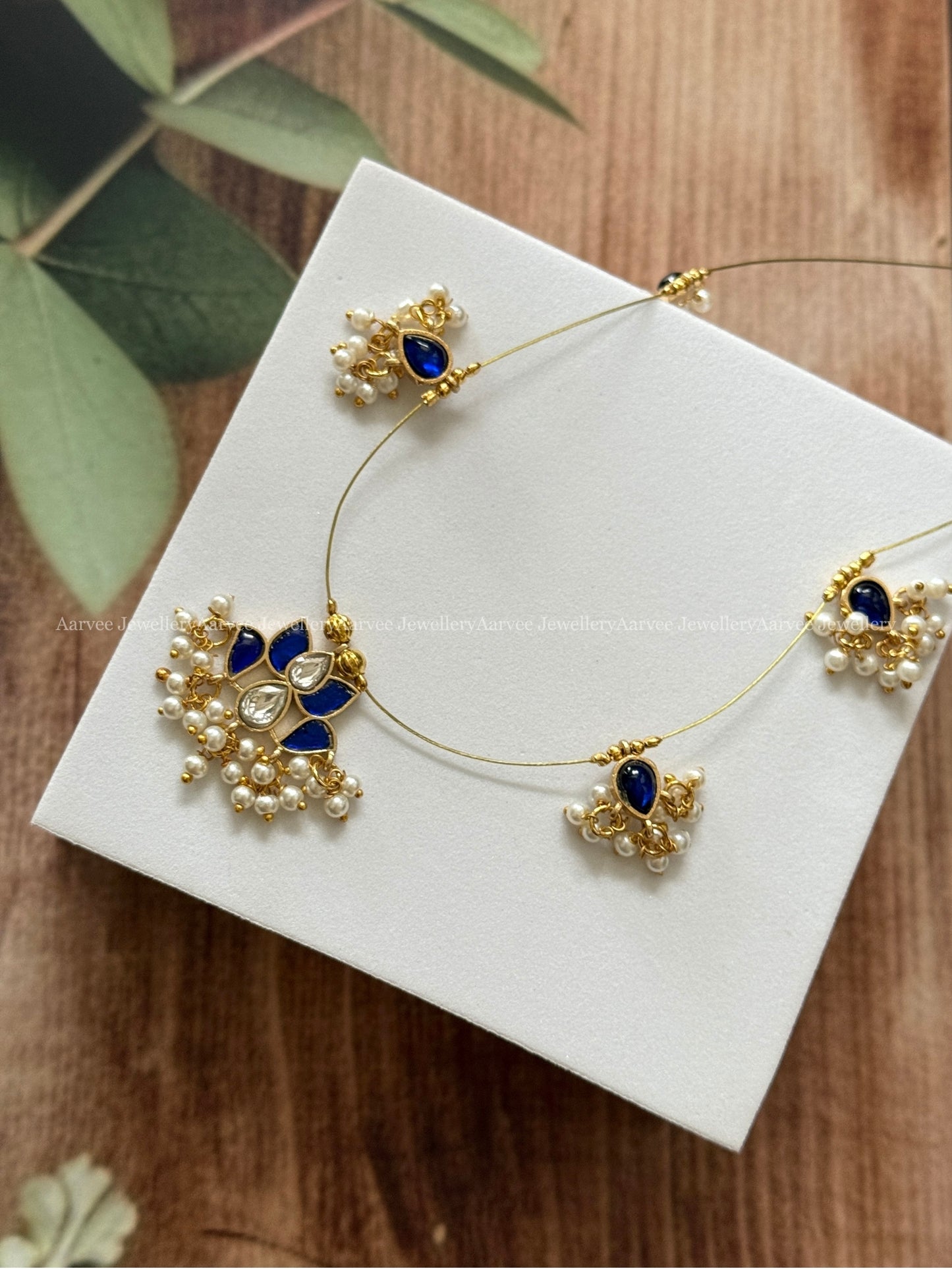 INVISIBLE CHAIN WITH LOTUS PENDANT IN BLUE / WHITE KUNDAN STONE