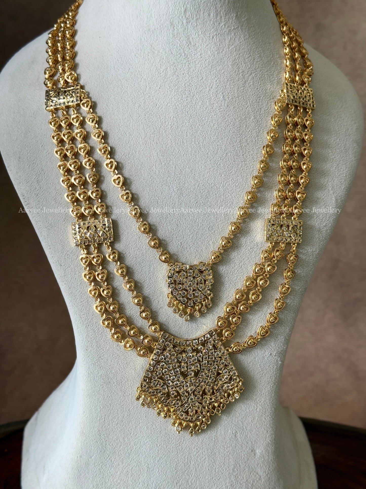GOLD FINISH LAYERED IMPON MID LENGTH HARAM SET WITH WHITE STONE