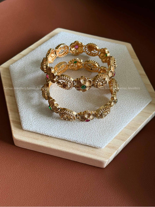 GOLD FINISH LAKSHMI AND FLORAL BANGELS IN RUBY / GREEN STONE