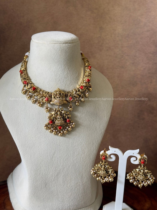 GOLD FINISH KANTI NECKLACE SET WITH LAKSHMI PENDANT IN CORAL STONES